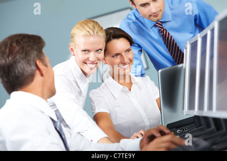 Group of four business people watching computer presentation together and discussing it Stock Photo
