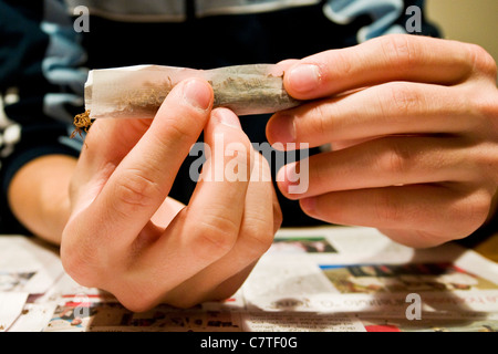 Young man's hands rolling marijuana joint, close up Stock Photo