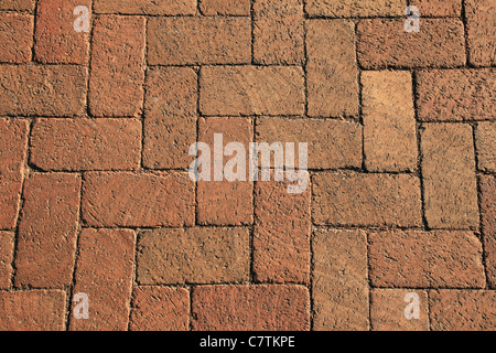 textured background of red bricks in a herringbone pattern from a walkway Stock Photo