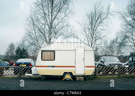 caravan with wheel clamp parked with a flat tyre Stock Photo