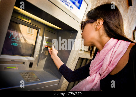 Woman using an ATM machine Stock Photo