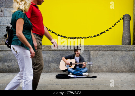 Teenage boy playing guitar in the street Stock Photo