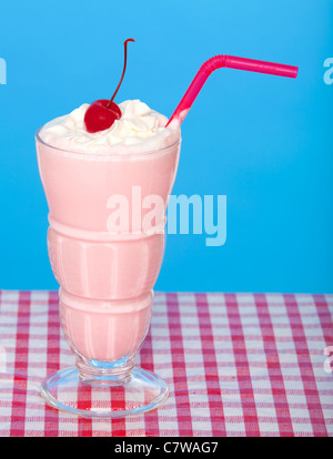 Strawberry milkshake on a picnic tablecloth with a blue background Stock Photo