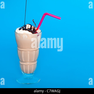 Chocolate shake with a drizzle of chocolate sauce on a blue background Stock Photo