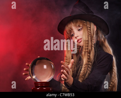 Little girl witch holding crystal ball. Stock Photo