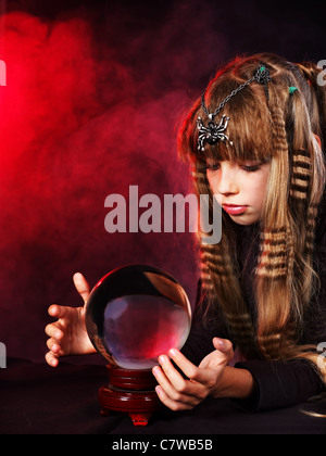 Little girl witch holding crystal ball. Stock Photo