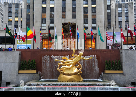 View, towards people and flags, gilded sculpture Prometheus, front GE Building, Rockefeller Centre Ice Rink, New York City, USA Stock Photo