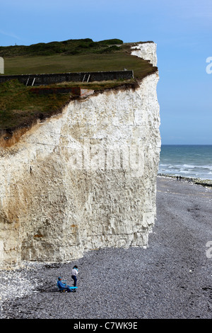 People on beach below chalk cliffs at Birling Gap , near Eastbourne , East Sussex , England Stock Photo