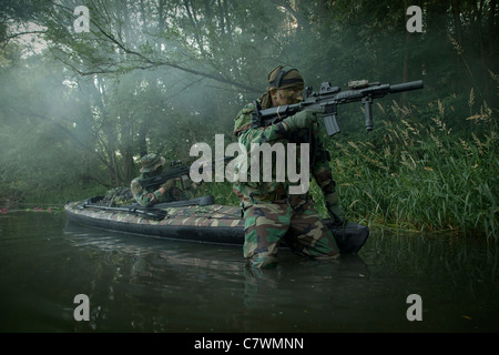 Navy SEALs navigate the waters in a folding kayak during jungle warfare operations. Stock Photo