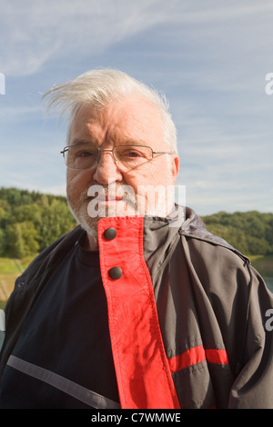Senior man smiling, wind, outdoors, close-up Stock Photo