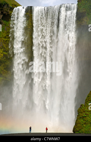 Tourists at Skogar waterfall in southwest Iceland. Stock Photo