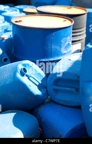 Old colored barrels for oil products. Empty rusted drums and blue canisters Stock Photo