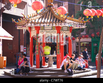 People sitting around a pagoda in Newport Street in London's Chinatown Stock Photo