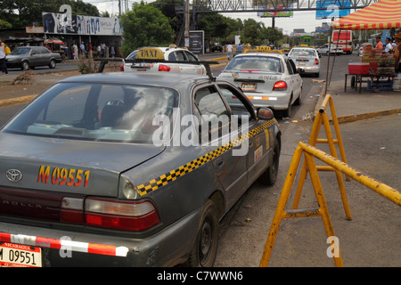 Managua Nicaragua,Central America,Metrocentro,district,street scene,traffic,car cars,taxi stop,cab,cabs,checkered,stripe,trash,transportation,visitors Stock Photo