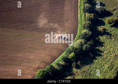 Aerial view of a single tractor in a dry field with dust billowing, tilling the dry soil, Stock Photo