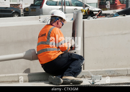 Workman connecting a street lamp East Manchester Line, Metrolink tram system. Edge Lane stop, Droylsden, Manchester, England, UK Stock Photo