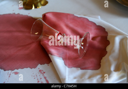 Red wine spilt on white table cloth uk Stock Photo