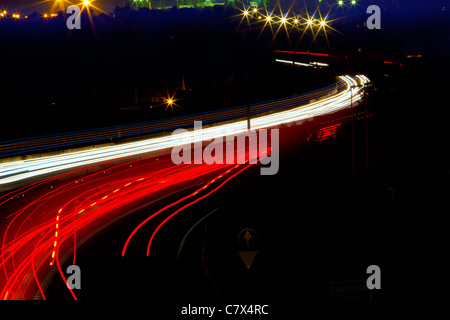 car light trails in red and white on night road curve