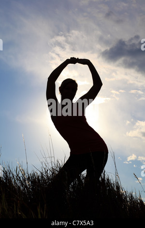 The silhouette of a gymnast stretching in a field Stock Photo - Alamy