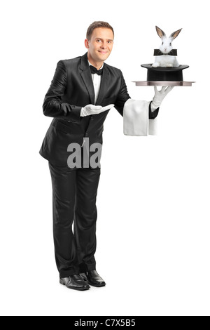 Full length portrait of a butler carrying a tray with a rabbit in a hat on it Stock Photo