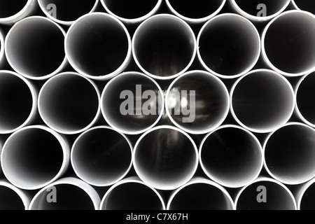 gray PVC tubes plastic pipes stacked in rows pattern Stock Photo