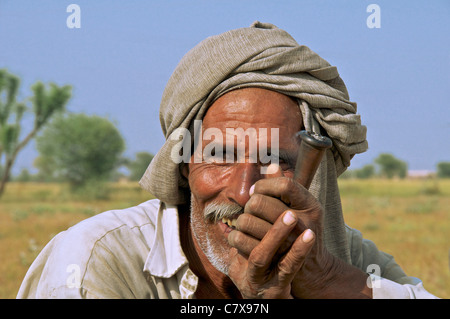Close-up portrait man smoking traditional pipe Rajasthan India Stock Photo