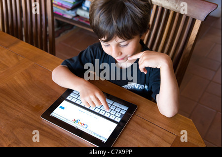 Child using Apple iPad 2 tablet computer at home Stock Photo