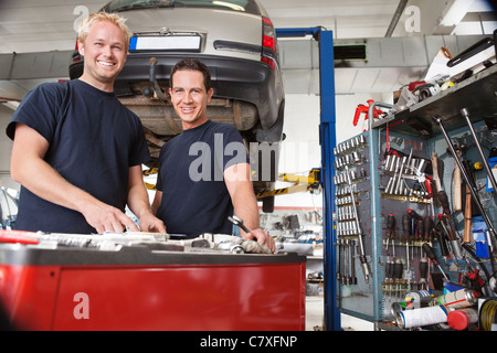 Two happy mechanics standing in garage Stock Photo