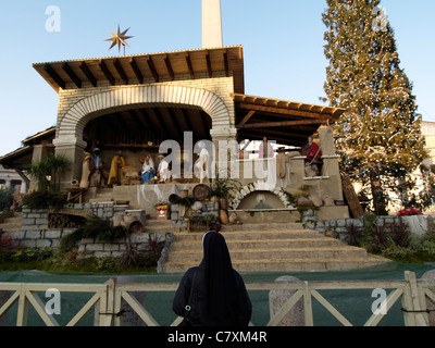 Religious tourism: a nun is admiring the nativity scene on Saint Peters square, the Vatican, Rome, Italy Stock Photo