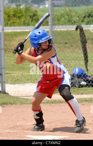 Teenage female Major league Softball players sitting on the bench with ...