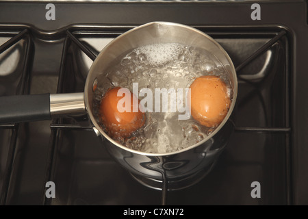 Two eggs being boiled in a saucepan Stock Photo