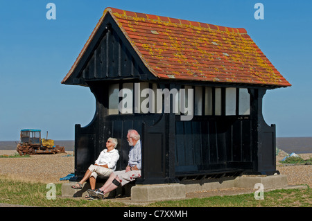 Elderly couple relaxing in the sunshine, Aldeburgh, Suffolk, UK. Stock Photo