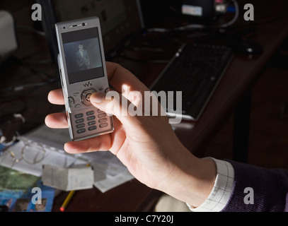 Male hand holding cellphone watching a picture Stock Photo