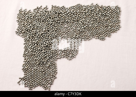 BB pellets on white surface shaped like a gun Stock Photo