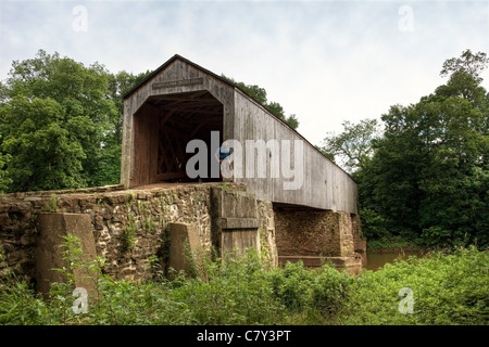 Man standing in front of Schofield Ford Covered Bridge in Tyler State Park, Pennsylvania Stock Photo