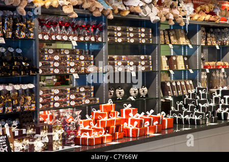 Gift boxes, packages and parcels of Belgian chocolates on display shelving in a chocolaterie in Bruges (Brugge) Stock Photo