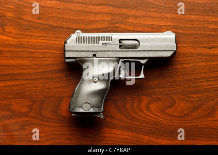 Top view of 9 mm handgun against wooden surface Stock Photo