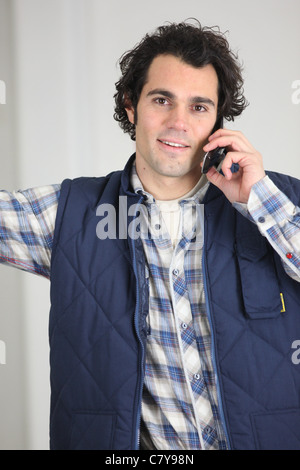 Workman using a cellphone Stock Photo