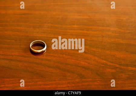 Gold ring on wooden surface Stock Photo