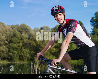 young man riding mountain bike, looking at camera Stock Photo