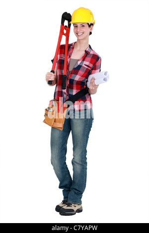 Tradeswoman holding large clippers and rolled-up drawings Stock Photo