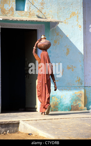 India, Rajasthan, Woman carrying water urns on her head Stock Photo