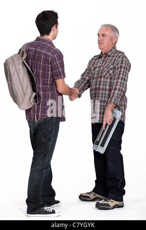 Experienced tradesman welcoming his new apprentice Stock Photo