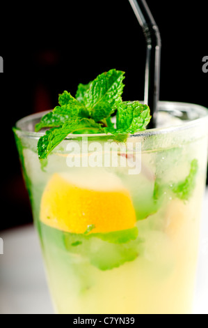 mojito caipirina cocktail with fresh mint leaves ,yerba-buena, with lime and black straw Stock Photo