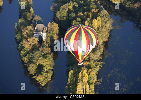 AIR-TO-AIR VIEW. Hot air balloon drifting over two small islands on the Cher River. Chisseaux, Centre-Val de Loire, France. Stock Photo
