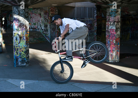 Grafitti-land on the South Bank, London- balancing cyclist Stock Photo