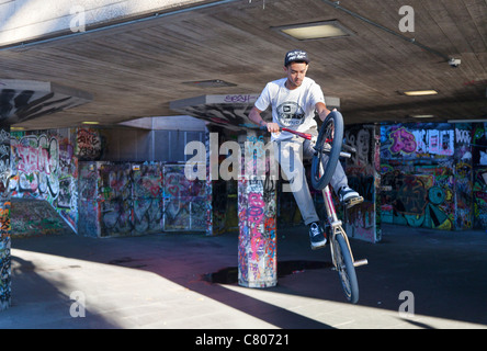 Grafitti-land on the South Bank, London- leaping cyclist Stock Photo