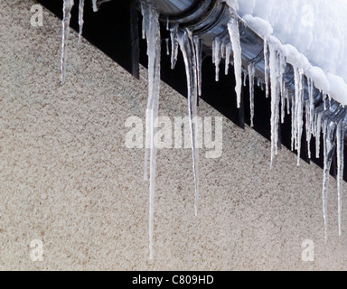 Icicles hanging from guttering on house during a spell of harsh winter weather Stock Photo