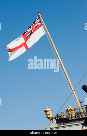 british white ensign flag flying against a blue sky on nelsons flagship victory Stock Photo