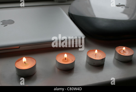 Apple computers with candles after death of Steve Jobs - side by side a new MacBook Pro with an old iBook laptop Stock Photo